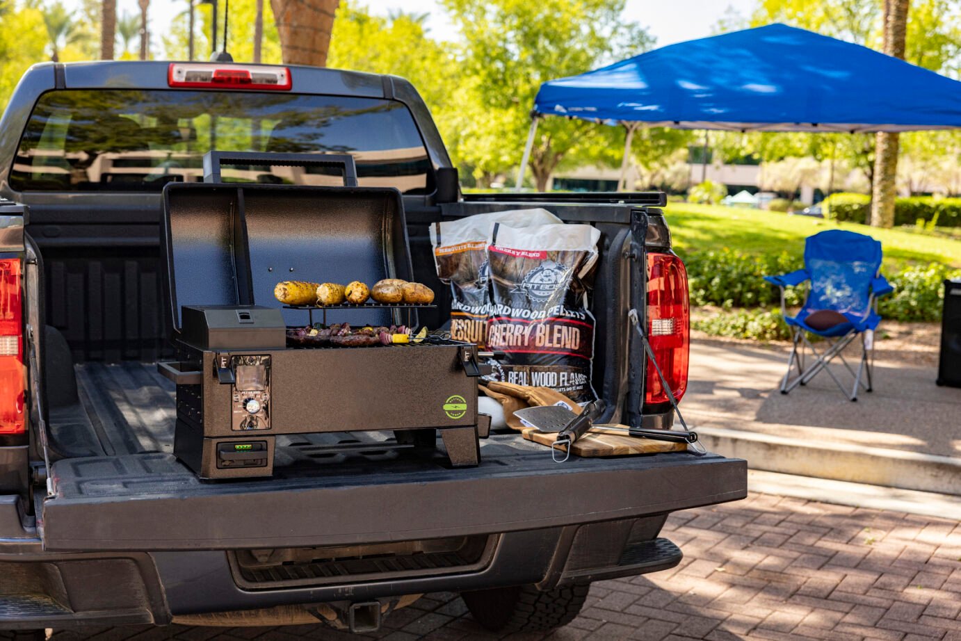 Pit Boss battery powered portable grill at football tailgate, compact cordless BBQ for game day cooking